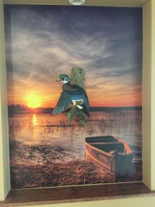 Lake Boat mural as backdrop for duck carving at Batesville Dental