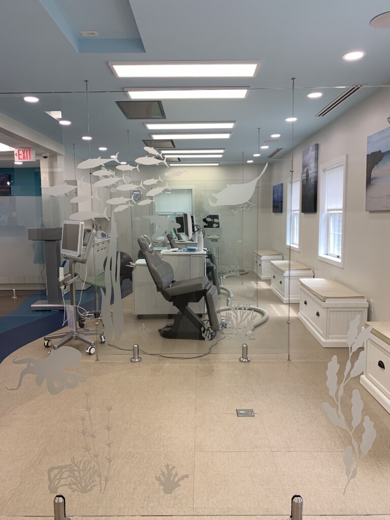 Drawing inspiration from the sand and sea, the tranquil color scheme of the area surrounding the dental chairs helps patients feel more relaxed. Glass dividers with iconic images of sea life