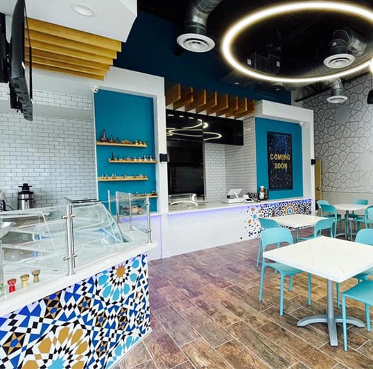 Houston's Shawarma Stop was designed and built out by Design+Build firm Vitruviuss General Contractor, which has outfitted a number of restaurants and cafes with our wallpaper murals over the years. Here they've wrapped the service counter, the meal prep 